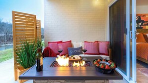 Un patio acogedor con una chimenea, zona de estar y vistas al exterior.