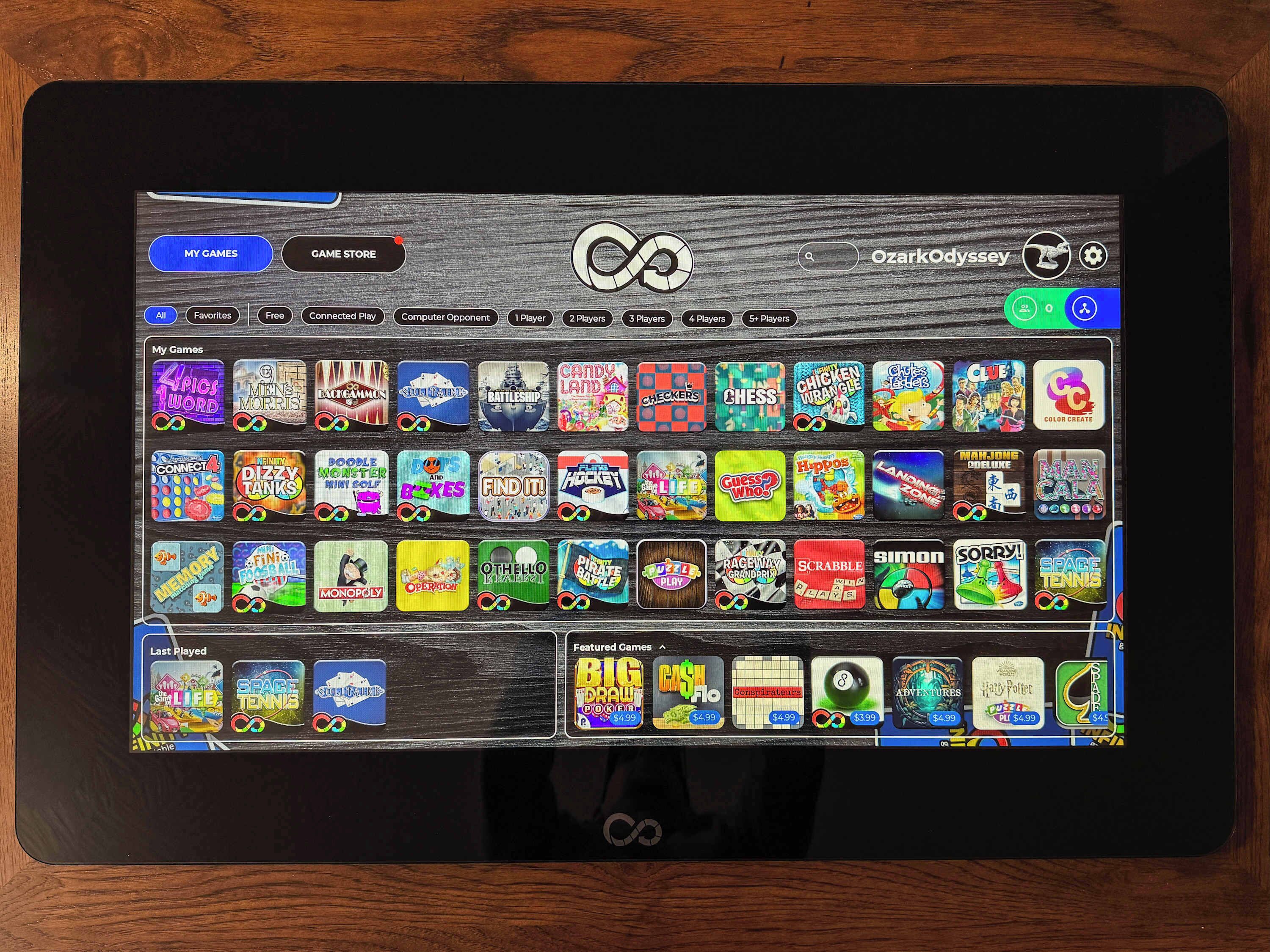 Ein Tablet zeigt eine Spielstore-Oberfläche mit verschiedenen Spiel-Icons und Kategorien.