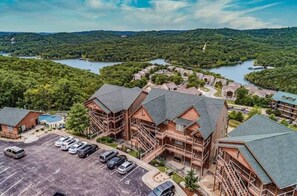 A lodge with multiple buildings, a parking lot, and a lake in the background. - L 4-5 Stunning Views, close to SDC 3 Beds (Branson)