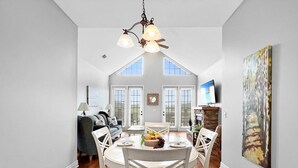 A dining area with a high ceiling, a chandelier, and a view through the windows. - L 7-8 Beautiful views, clean, cozy and close to SDC (Branson)
