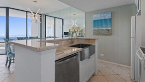 A modern kitchen with a large island, stainless steel appliances, and a view of the ocean. - 2-Level Beachfront Resort Condo w/Views of Beach & Bay! (South Padre Island)