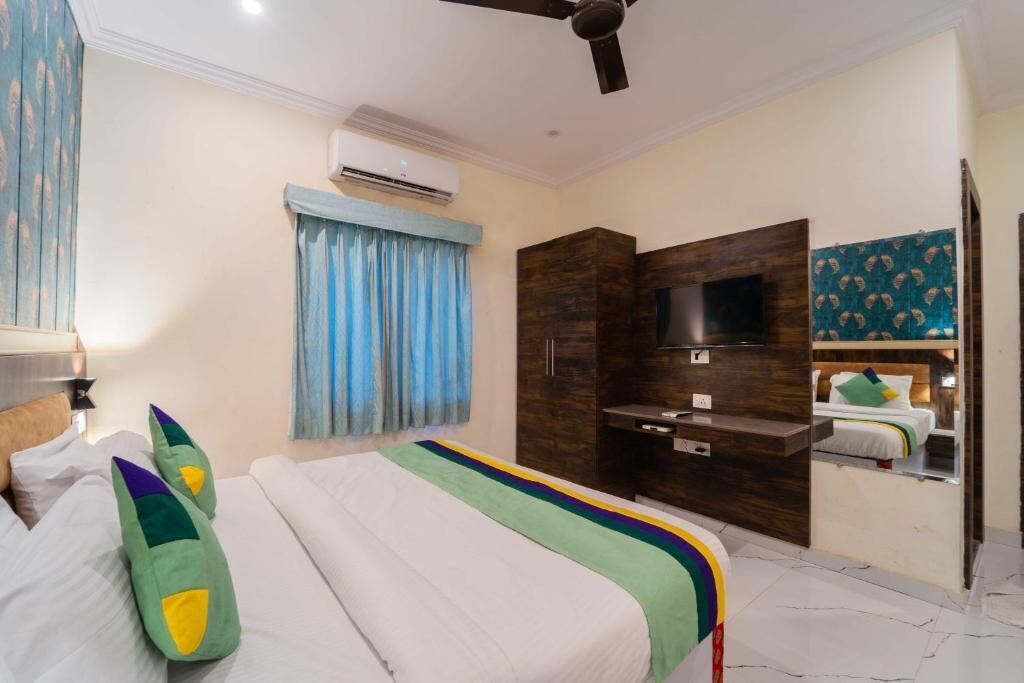 Ein Hotelzimmer mit Bett, Fernseher, Kleiderschrank und Klimaanlage.