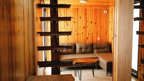 A wooden interior with a sofa and a small table. - Horma Kanyon Otel (Pinarbasi)
