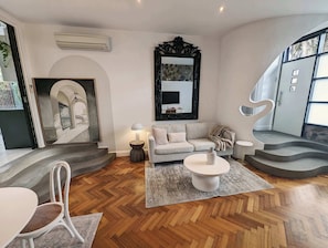 A modern living room with a sofa, coffee table, and a staircase. - European Style Escape in Geelong (Geelong)