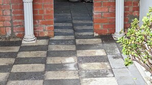 Una entrada de ladrillo con arco y un sendero a cuadros que lleva a una puerta.