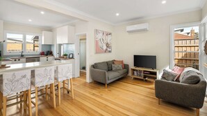 Un apartamento moderno con cocina, comedor, sala de estar y balcón.