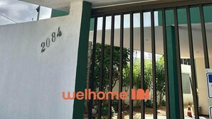 Un edificio de varios pisos con fachada verde y blanca, con número 2084, que cuenta con balcones y ventanas amplias.