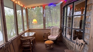A cozy room with a wooden interior, a round table, and several chairs.