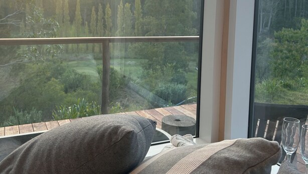 A room with a large window offering a view of a forested landscape.