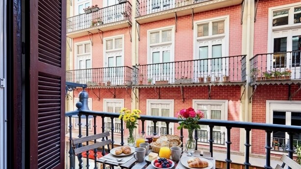 A balcony with a table set for breakfast, including croissants, fruit, and juice. - "Pamplona center suites" luxury Apartment city center (Pamplona)