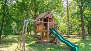 A wooden playhouse with a slide and a ladder. - Spacious 4 bedroom home with large yard (Wayland)