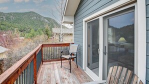 A balcony with a chair, a table, and a sliding glass door. - Lazy Dayz- Downtown Estes Park and Less Than 5 minutes to RMNP Entrance! (Estes Park)