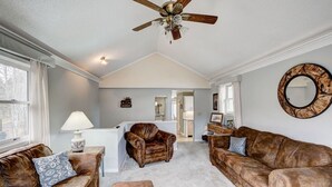 A living room with leather sofas, a ceiling fan, and a kitchen in the background. - Lazy Dayz- Downtown Estes Park and Less Than 5 minutes to RMNP Entrance! (Estes Park)