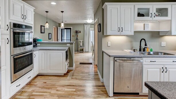 A kitchen with white cabinetry, a central island, and a built-in oven. - Lazy Dayz- Downtown Estes Park and Less Than 5 minutes to RMNP Entrance! (Estes Park)