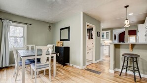 A modern kitchen with white cabinets, a black countertop, and a hanging light fixture. - Lazy Dayz- Downtown Estes Park and Less Than 5 minutes to RMNP Entrance! (Estes Park)