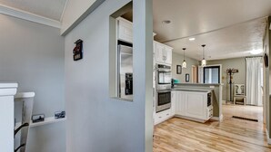 A modern kitchen with white cabinetry, stainless steel appliances, and a wooden floor. - Lazy Dayz- Downtown Estes Park and Less Than 5 minutes to RMNP Entrance! (Estes Park)