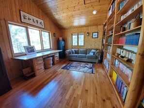 A wooden interior with a desk, sofa, and bookshelves. - Ridgeview-Nestled in the heart of wilderness with Acreage! (Allenspark)