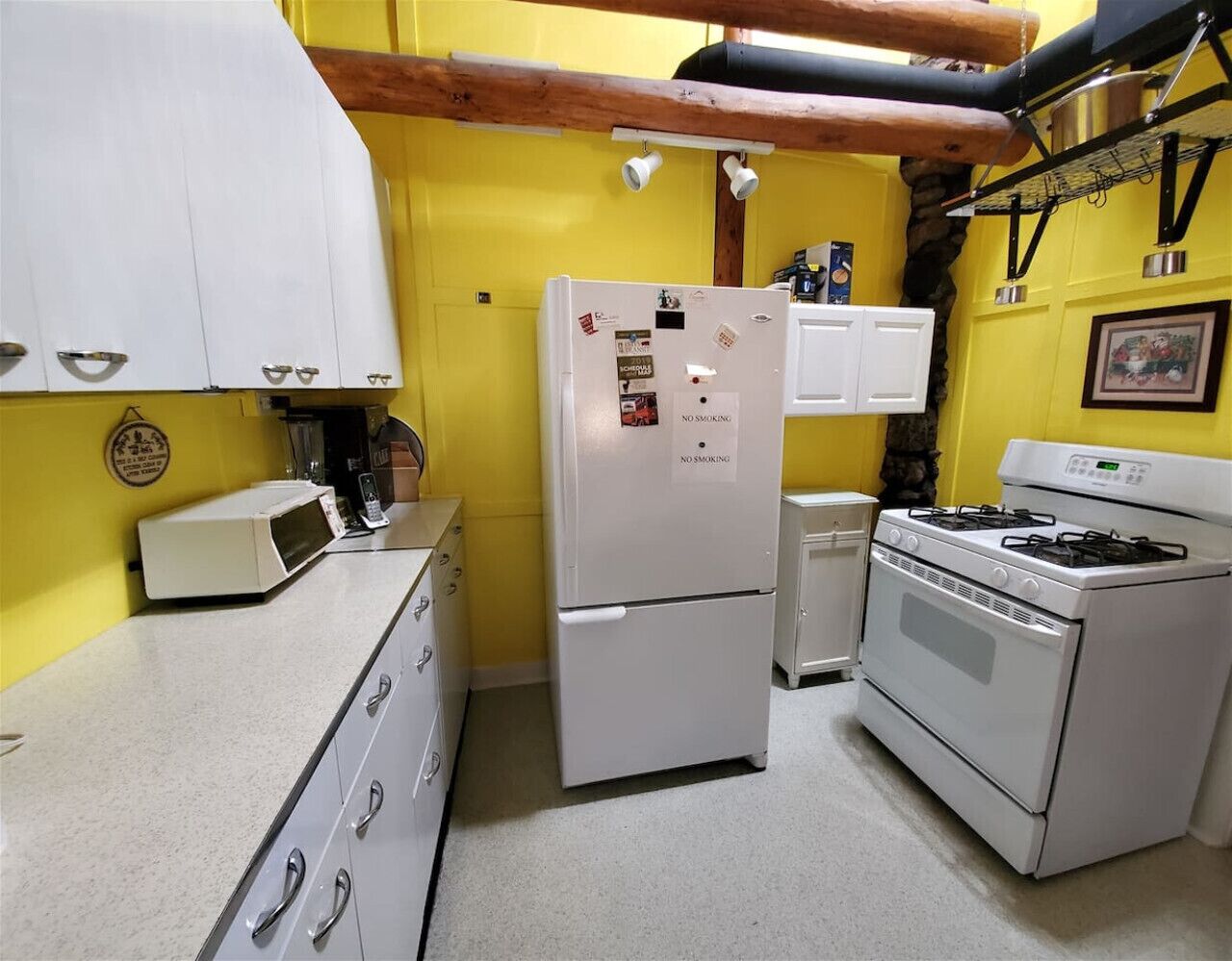 A compact kitchen with a refrigerator, microwave, stove, and cabinets.