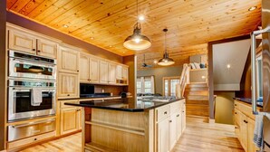 A spacious kitchen with wooden cabinets, a central island, and stainless steel appliances.