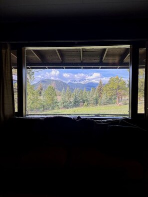 Una habitación con un ventanal grande que da a un paisaje montañoso.
