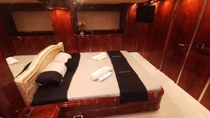Ein luxuriöses Schlafzimmer mit einem großen Bett, einem Holz-Kopfteil und einem wandmontierten Flachbildfernseher.