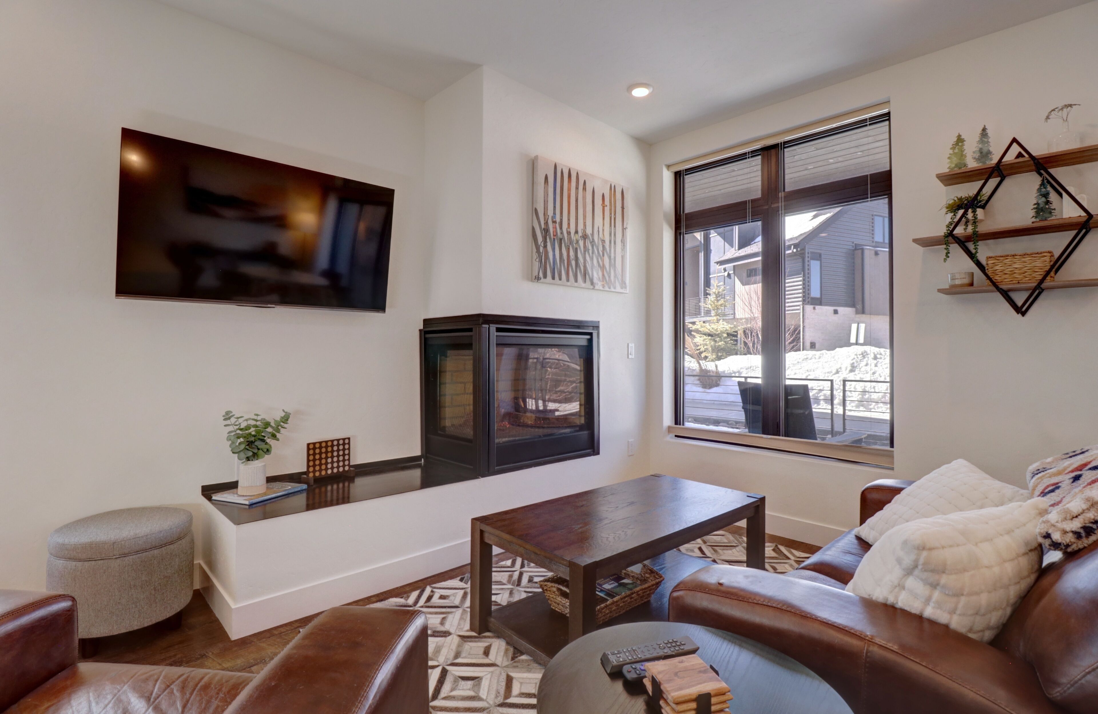 A living room with a fireplace, a television, a coffee table, and a couch.