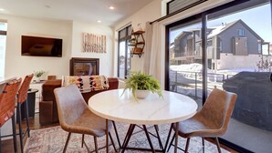 A modern living room with a round table, two chairs, a sofa, and a TV mounted on the wall. - River West 515 2 Bedroom Condo (Silverthorne)