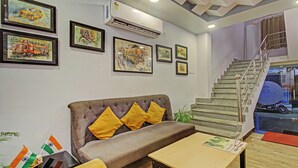 Un vestíbulo con un sofá, una mesa y una escalera.