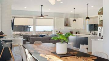 A modern kitchen with white cabinets, a central island, and pendant lighting.