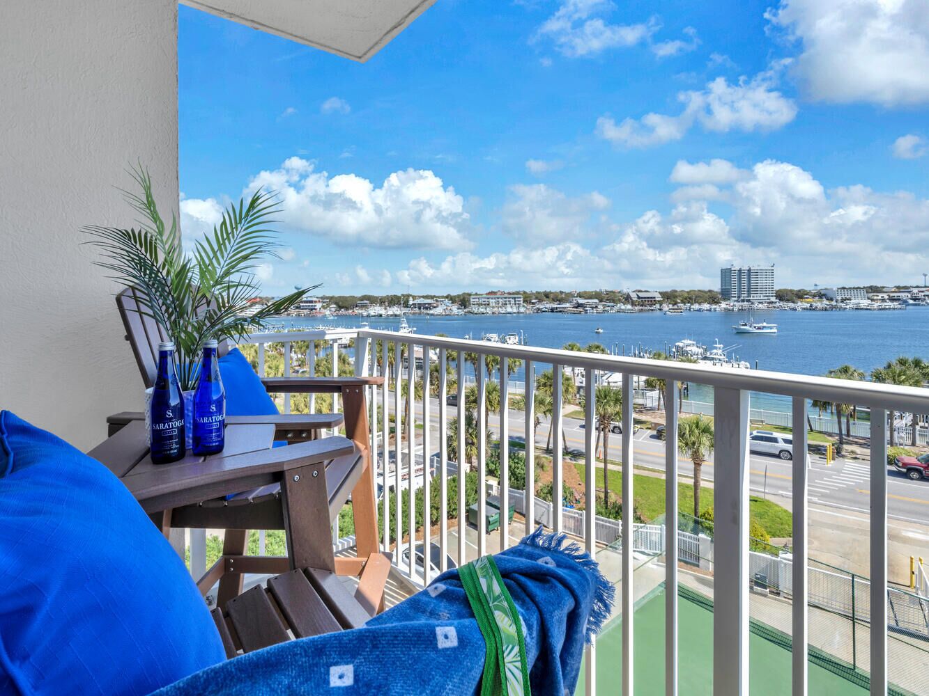 A balcony with a view of a marina and a cityscape.