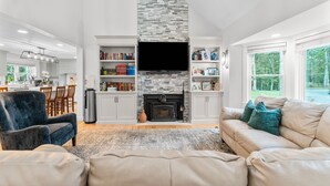 A living room with a fireplace, bookshelves, a sofa, and a TV.