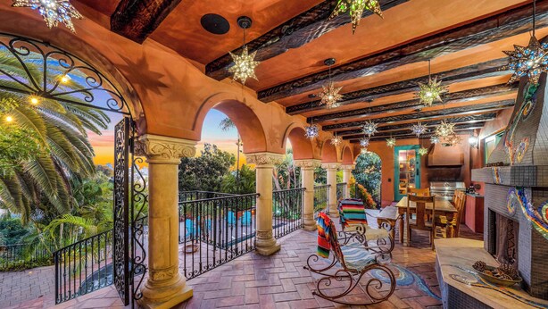 Un patio amplio con chimenea, asientos exteriores y luces decorativas con forma de estrella.