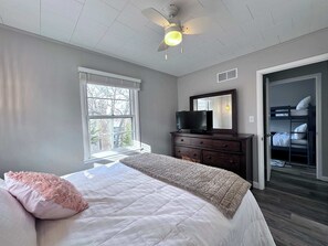 Cozy retreat with a large bed, flat-screen TV, and a separate bunk bed area.