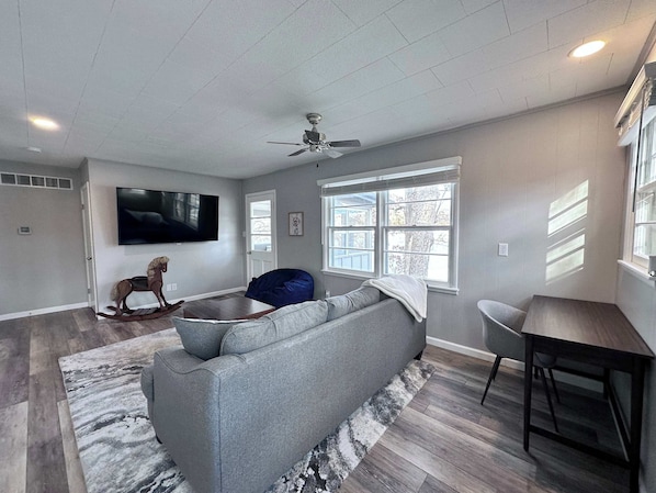 Relax in this stylish living room with a large sofa, bean bag chair, and flat-screen TV.