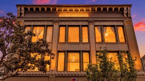A building with the sign 'WOOLWORTH BUILDING' at the top, large windows, and a classic architectural style. - Woolworth Loft – Elegant Stay w/ City Views (San Diego)
