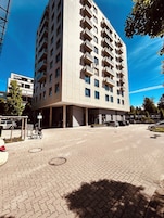 Un edificio de varios pisos con fachada plana, ventanas amplias y balcones.