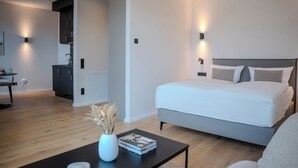 A modern bedroom with a large bed, bedside tables, and a small desk area. - The MYDE Hamburg Serviced Apartments (Hamburg)