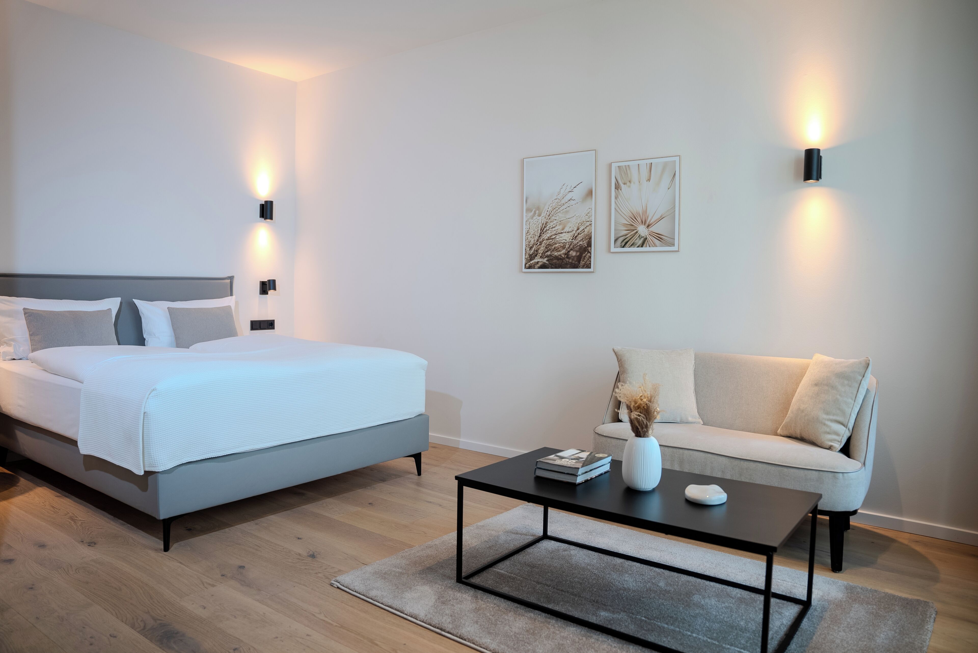 A modern bedroom with a bed, a sofa, and a coffee table.