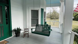 A porch with a ceiling fan, a green bench, and a potted plant. - “Down Home” - Charming Antebellum Farm House (Edgefield)