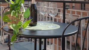 En balkong med ett bord dukat för två personer, med en flaska champagne och två vinglas.