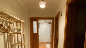 A hallway with a wooden shoe rack, a patterned rug, and a wooden door at the end. - 2-bedroom apartment in fabulous Alanya with WiFi, AC (Antalya)