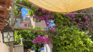A lantern hanging outdoors, surrounded by lush greenery and purple flowers. - Superior Apartment to Pompeii (Boscoreale)