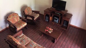 A living room with a sofa, armchairs, a coffee table, a TV, and a fireplace. - Holiday home in Araruama/ Praia Seca. Located in the Palm Beach condominium (Praia Seca)