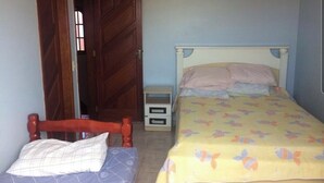 A bedroom with a bed, a wooden wardrobe, and a small bedside table. - Holiday home in Araruama/ Praia Seca. Located in the Palm Beach condominium (Praia Seca)