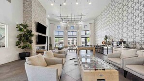A spacious lobby with modern furniture, a foosball table, and a patterned wall.