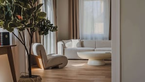 Un salon moderne avec un canapé beige, une table basse blanche et un plancher en bois.