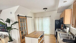 A modern kitchen with wooden cabinets, a granite countertop, and a built-in stove.