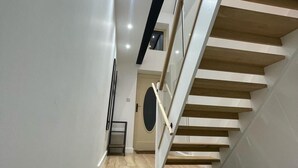 Un escalier moderne avec des marches en bois et une rampe en verre.