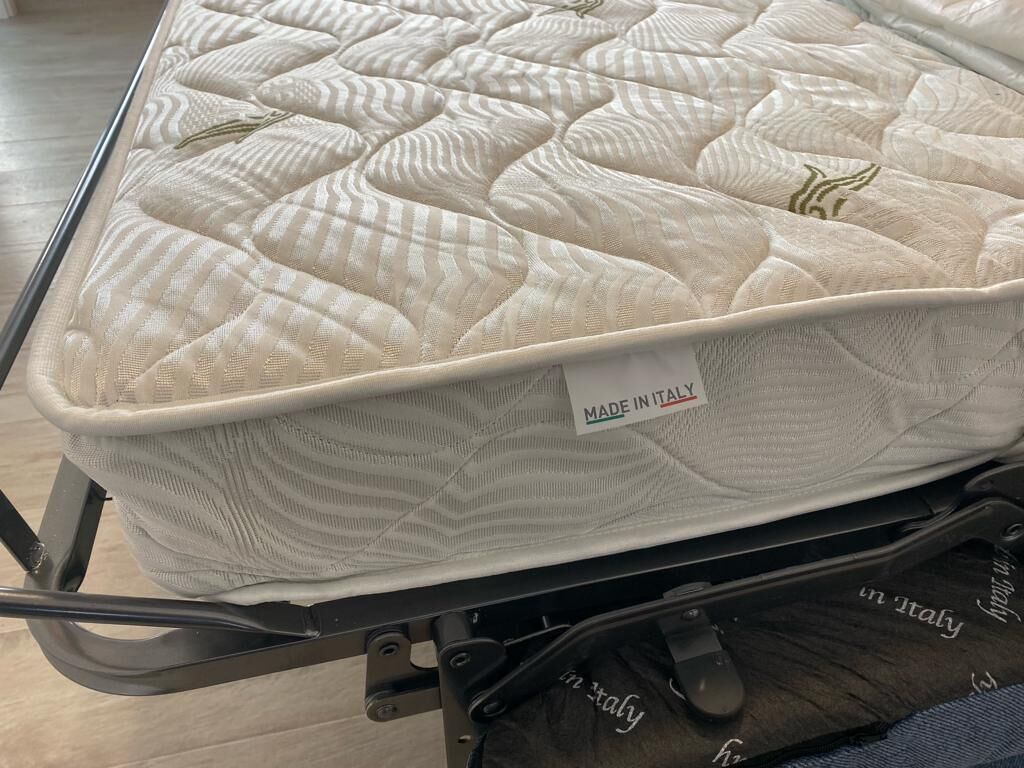 A mattress with a quilted design and a label indicating it is made in Italy.