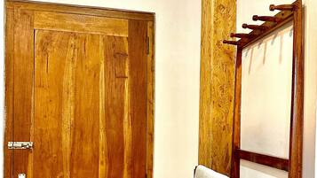 A wooden door with a metal handle and a towel hanging on a towel rack.